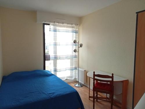 une chambre avec un lit, un bureau et une fenêtre dans l'établissement La Rochelle - 3 pièces avec piscine, parking, animaux admis, proche plage - FR-1-551-1, à La Rochelle