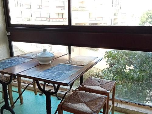 une table et deux chaises dans une pièce avec une fenêtre dans l'établissement La Rochelle - 3 pièces avec piscine, parking, animaux admis, proche plage - FR-1-551-1, à La Rochelle