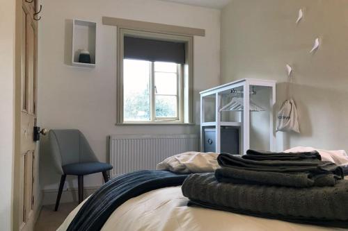 een slaapkamer met een bed met een stoel en een raam bij Grade II Townhouse, Ledbury in Ledbury