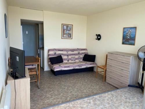 un salon avec un canapé et une télévision dans l'établissement Charmant studio avec balcon et parking, près du port - FR-1-551-20, à La Rochelle