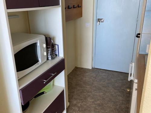 Cette petite chambre dispose d'une télévision et d'une porte. dans l'établissement Charmant studio avec balcon et parking, près du port - FR-1-551-20, à La Rochelle