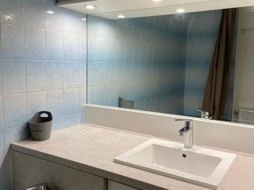 une salle de bain avec un lavabo et un miroir dans l'établissement Charmant studio avec balcon et parking, près du port - FR-1-551-20, à La Rochelle