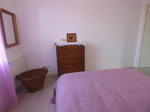 - une chambre avec un lit, une commode et un panier dans l'établissement Maison lumineuse 2 ch entre campagne et mer, proche golf et La Rochelle, parking et local vélo - FR-1-551-22, à Marsilly