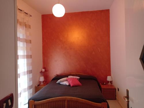 a bedroom with a bed with a red wall at Casa Vacanza Da Andrea in Naples