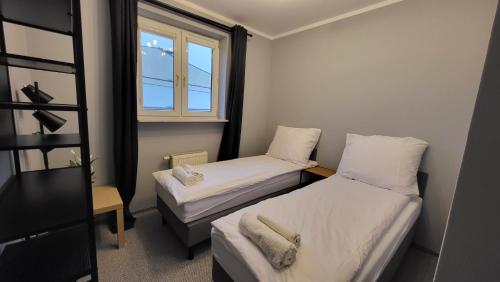mały pokój z 2 łóżkami i oknem w obiekcie Apartament Skarbka w Warszawie