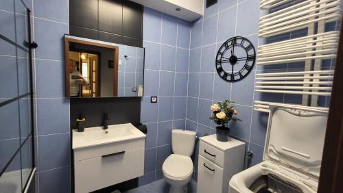 niebieska łazienka z toaletą i umywalką w obiekcie Apartament Skarbka w Warszawie
