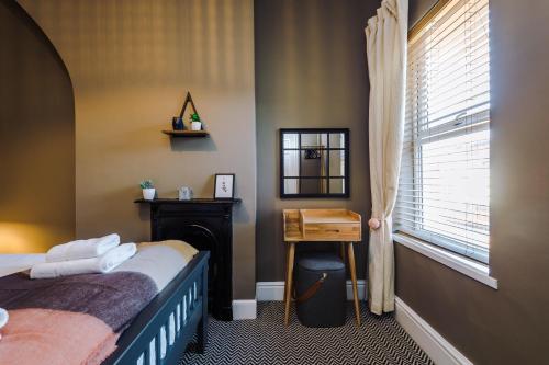 a bedroom with a bed and a desk and a window at Cornwall House in Chester
