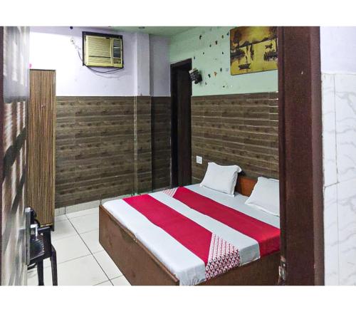 a bedroom with a bed with a red and white blanket at Toran Guest House By WB Inn in Agra