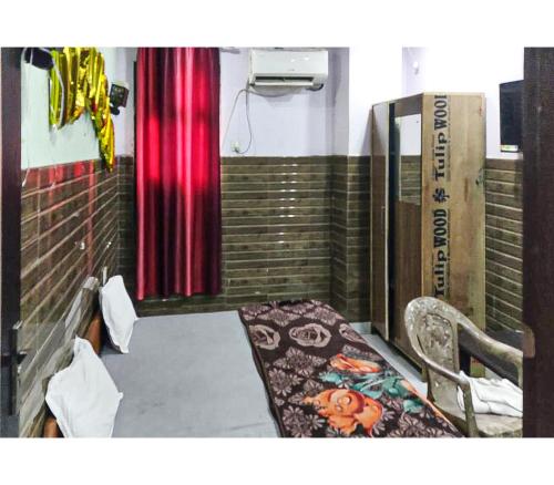 een kamer met een bed, een stoel en een gordijn bij Toran Guest House By WB Inn in Agra