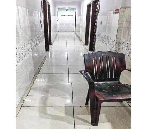 een stoel op een tegelvloer in een gang bij Toran Guest House By WB Inn in Agra