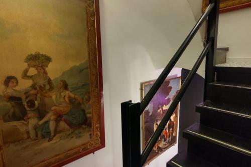 a painting hanging on a wall next to a staircase at Madrid Centro, Edificio Entero Solo Para Ti in Madrid