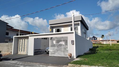 a white house with a dog in front of it at salinopolis atalaia in Salinópolis