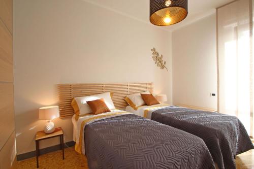 a bedroom with two beds and a lamp on a table at Appartamento Dei Ronchi in Marina di Massa