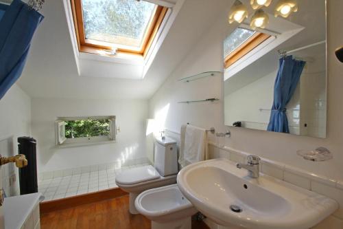 a bathroom with a sink and a toilet and a mirror at Villa Poveromo in Massa