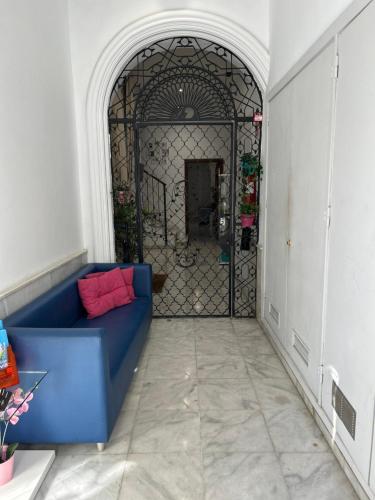 a blue couch in a room with a gate at The Spot Central Hostel in Seville
