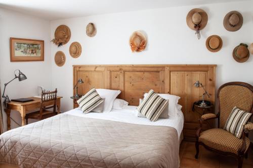 a bedroom with a bed and two chairs at Le Clos Du Buis in Bonnieux