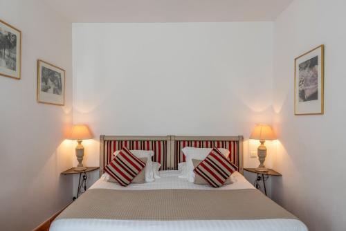 a bedroom with a large bed with two lamps at Le Clos Du Buis in Bonnieux