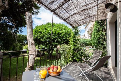 a table with a bowl of fruit on a balcony at Le Clos Du Buis in Bonnieux