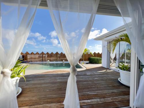 ein Festzelt mit einem weißen Vorhang und einem Pool in der Unterkunft Villa Amaryllis luxueuse,piscine,vue mer,plage in Sainte-Luce
