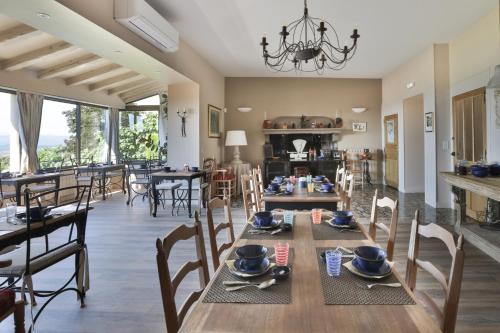 a dining room and living room with a table and chairs at Le Clos Du Buis in Bonnieux
