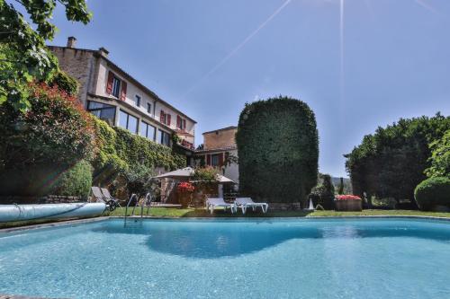 a swimming pool in front of a house at Le Clos Du Buis in Bonnieux
