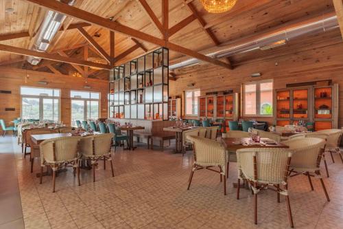 a restaurant with wooden ceilings and tables and chairs at Pestana Douro Riverside - Preferred Hotels & Resorts, Lifestyle in Porto