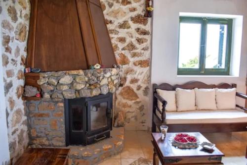 a living room with a fireplace and a couch at Villa Andreas-Dimitris in Volimes