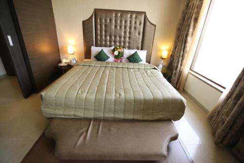 a bedroom with a large bed with a large window at SilverCloud Hotel and Banquets in Ahmedabad