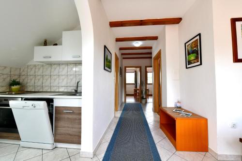 une cuisine avec des appareils blancs et un tapis bleu dans l'établissement Guest House Family Dukić, à Rakovica