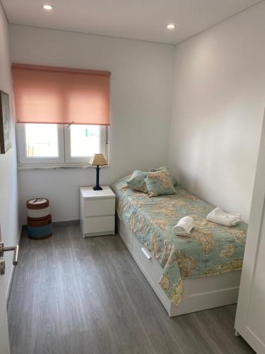 a bedroom with a bed and a window at Casa Berlenga in Peniche