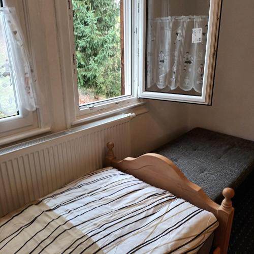 a bed in a room with two windows at Bei Rosario in Steinach