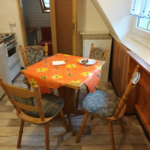 een eettafel en stoelen met een oranje tafel bij Bei Rosario in Steinach