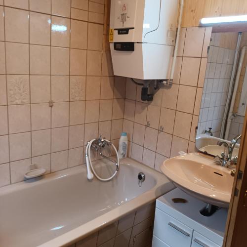 ein Badezimmer mit einer Badewanne und einem Waschbecken in der Unterkunft Bei Rosario in Steinach