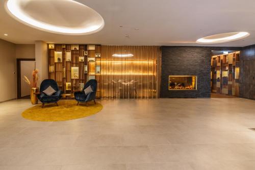 a lobby with two chairs and a fireplace at Kranz Parkhotel in Siegburg