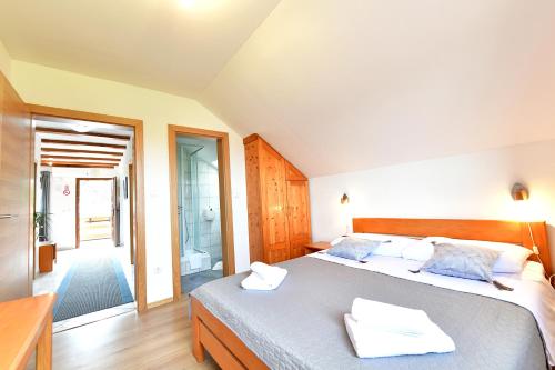 a bedroom with a bed with two towels on it at Guest House Family Dukić in Rakovica