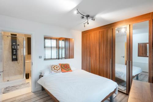 1 dormitorio con cama blanca y baño en Modern Central 2bed 2bath Stratford Apt en Londres