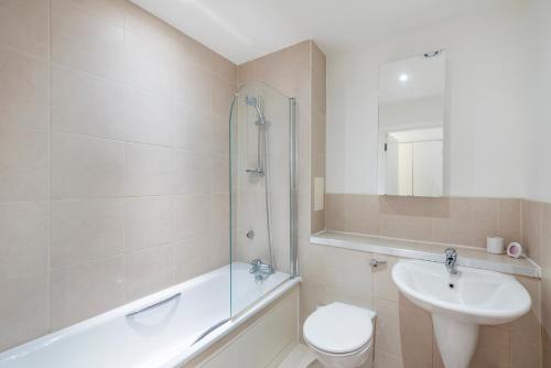 y baño con lavabo, aseo y ducha. en Modern Central 2bed 2bath Stratford Apt en Londres