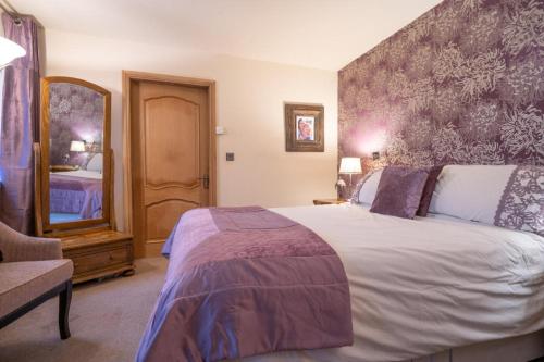 ein Schlafzimmer mit einem großen Bett und einem großen Spiegel in der Unterkunft Heron House in Haverigg