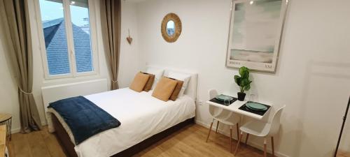 1 dormitorio con cama, mesa y ventana en Garnavie - Centre ville - Les Halles, en Lourdes