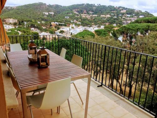a wooden table and chairs on a balcony with a view at 2 Story, 5 Bedroom, 3 Bath Flat, Steps from the Beach & Cliff Walk in Llafranc