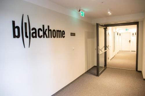 a hallway with a blackhorn sign on the wall at Blackhome Wien I contactless check-in in Vienna