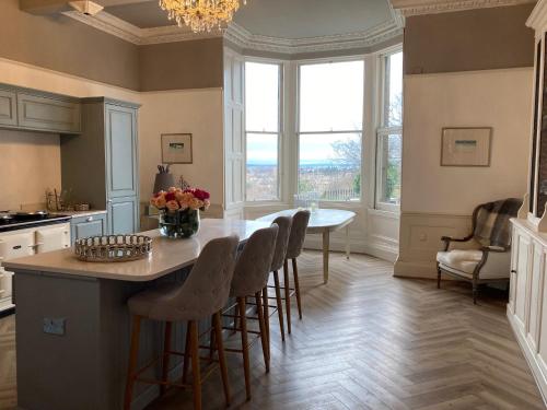 a kitchen with a table with chairs and a large window at West End Townhouse in Edinburgh
