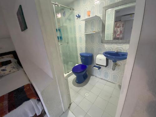a bathroom with a shower and a blue toilet at House Marfito Airport in Cartagena de Indias