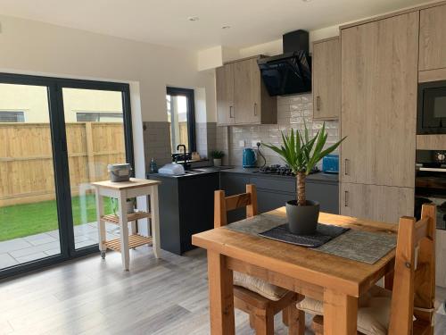a kitchen with a wooden table with a potted plant on it at Surfers Lodge - Rest Bay, Porthcawl in Porthcawl