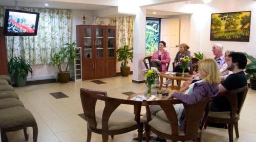 grupa ludzi siedzących przy stole w pokoju w obiekcie Hillview Inn Cameron Highlands PROMO w mieście Tanah Rata