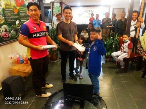 a group of men playing a video game with a boy at Hillview Inn Cameron Highlands PROMO in Tanah Rata