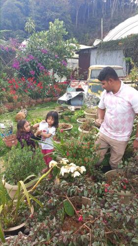 a man and two children standing in a garden at Hillview Inn Cameron Highlands PROMO in Tanah Rata