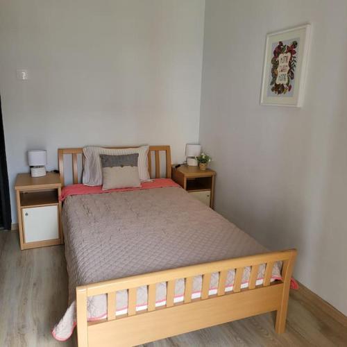 a bedroom with a wooden bed with two night stands at BEAUTIFUL APARTMENT IN VERIA in Veria