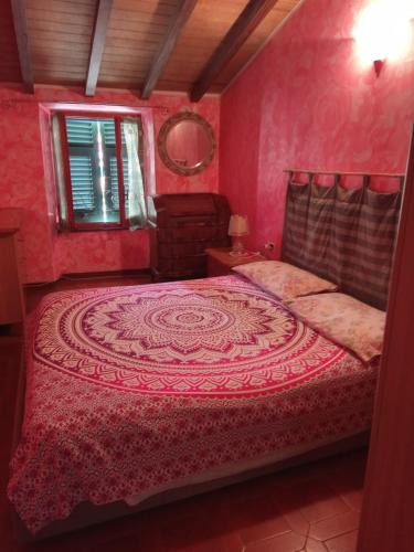 una camera rosa con un letto di Soledad a Bonassola