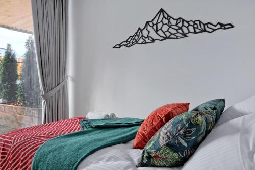 a bedroom with a bed with red and green pillows at Apartament Morskie Oko Odkryj Zakopane in Zakopane